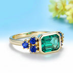 Trilogie Moissanite Emerald Sapphire Ring – close-up of emerald and sapphire